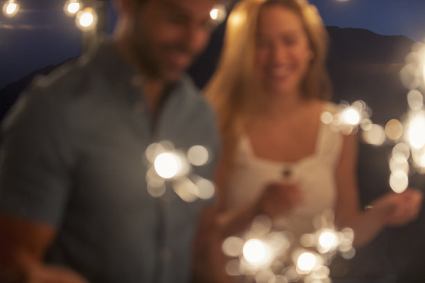 一群朋友在玩烟花。他们在笑，玩得很开心。图片下载