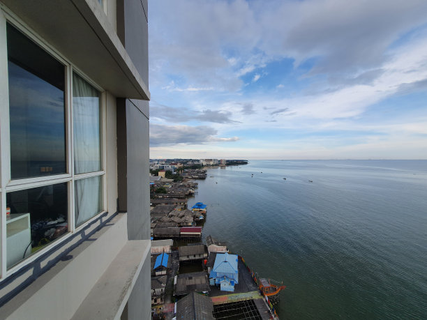 印度尼西亚，巴厘巴潘城海湾，从酒店阳台俯瞰，碧海海水与平静的海浪和多云的天空地平线在远处可见图片下载