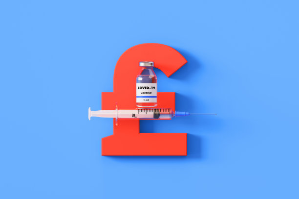 注射器和COVID-19疫苗瓶放在蓝色背景的英镑符号上图片下载