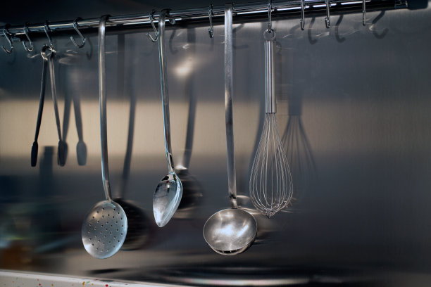 经典风格的不锈钢厨房工具集在厨房墙壁上图片下载