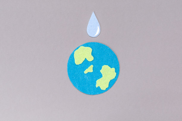 世界水日。用毛毡雕刻出的是地球的象征和一滴水。灰色的背景。副本的空间。环境保护的概念图片下载