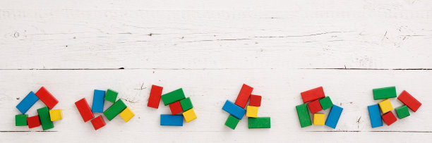 俯视图上的彩色木制玩具积木上的白色背景木桌。宽图片下载