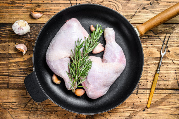 生鸡腿在平底锅里准备烧烤。木制背景。俯视图图片下载