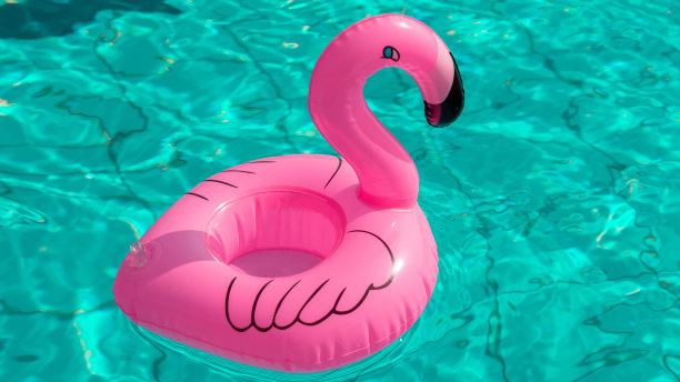 夏天出售。粉红色的充气火烈鸟在游泳池的水为夏天的海滩背景。最小的夏天的概念。图片下载