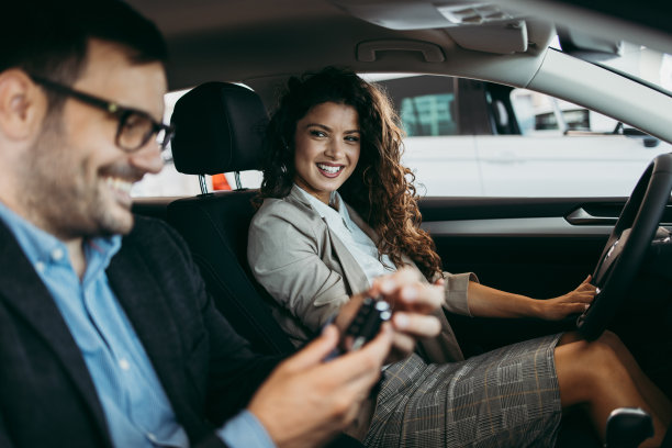 迷人的中年夫妇购买汽车在展厅图片下载