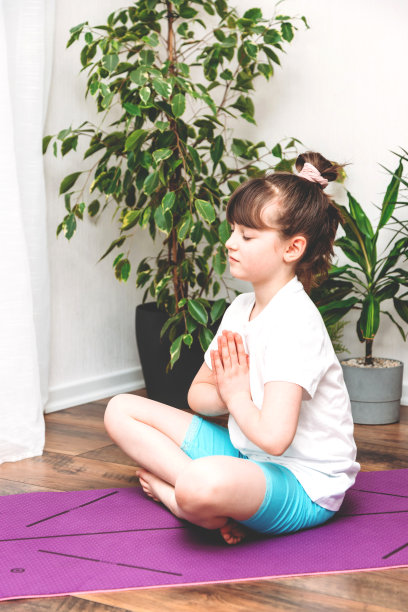 可爱的白人女孩在家里做体操，健身或瑜伽在一个粉红色的垫子上。运动，儿童拉伸，在线课程和培训。图片下载