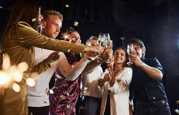 把眼镜。一群欢快的朋友在室内喝着酒庆祝新年图片下载