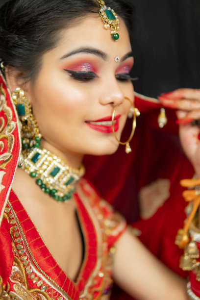 美丽的印度新娘肖像在红色lehenga和珠宝。图片下载