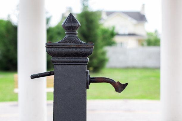Сity水龙头与饮用水在公园。公园里的铁饮柱。古老的黑色水柱安装在街道上分配饮用水。关闭户外消火栓上的乡村水龙头图片下载