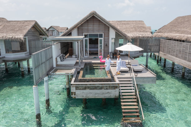 无人机的夫妇放松在水上私人别墅图片下载