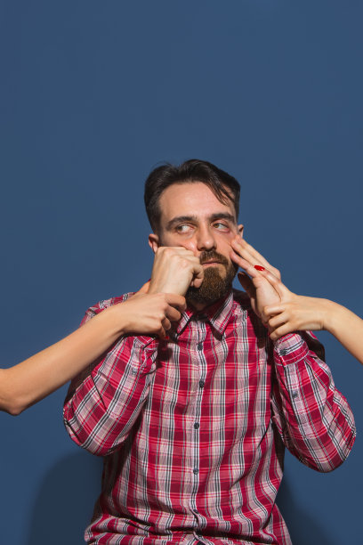 年轻的胡子英俊男子的肖像孤立在蓝色的背景图片下载