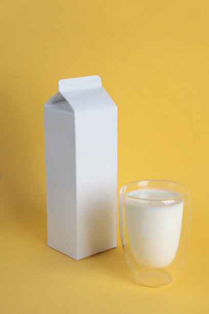 发酵牛奶概念-白色包装和玻璃凯斐隔离在黄色背景图片下载