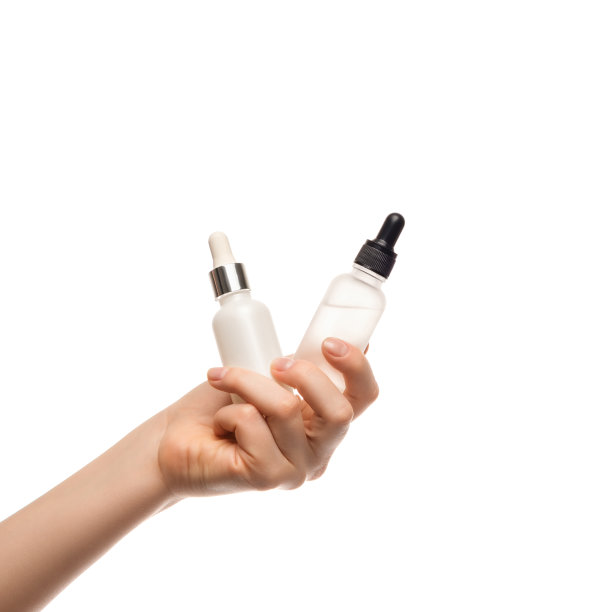 一个女人手里拿着几瓶血清，背景很亮。保湿霜，维他命C，透明质酸。图片下载