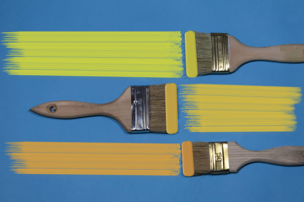 在蓝色的背景上，三个带有黄色色调的笔刷图片下载