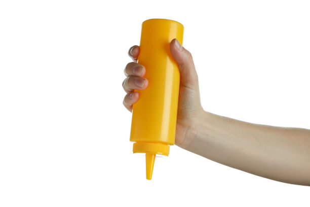 女手里拿着黄色的酱瓶，孤立在白色的背景上图片下载