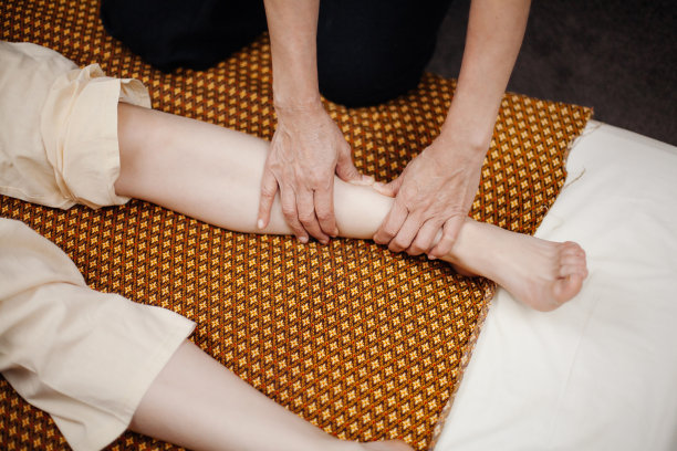 女人在女孩的腿上做泰式按摩图片下载
