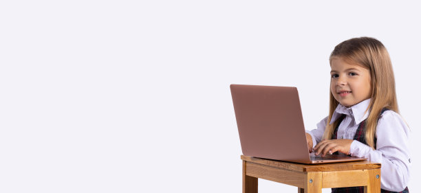 横幅,长格式。一个女学生微笑着坐在笔记本电脑前。在线学习的概念。大流行期间的远程学习。背景与侧广告空间。图片下载