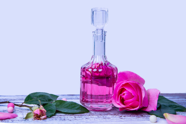 玻璃瓶里的玫瑰香水。在白色背景上注入花瓣的化妆品爽肤水图片下载