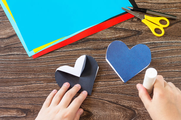 指令步骤8。父亲节心形贺卡和燕尾服放在木桌上。手工制作的。儿童创意项目，工艺品，儿童工艺品。图片下载