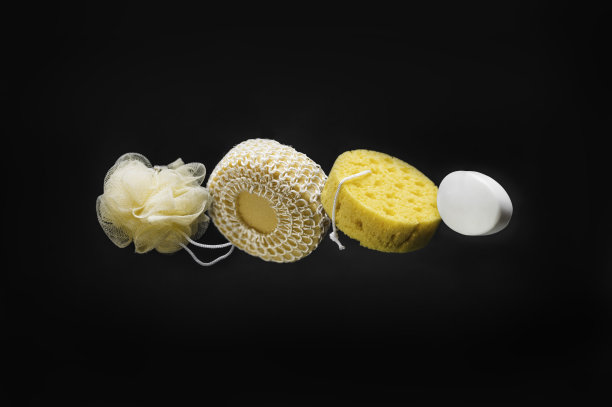 黑色背景上的各种肥皂和沐浴海绵图片下载