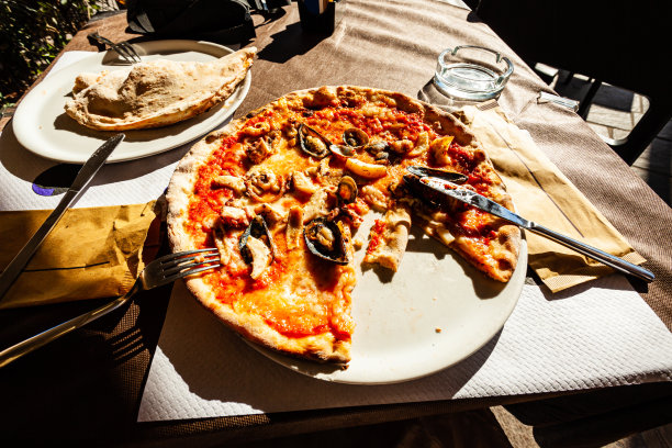 阳光明媚的日子，街边咖啡馆的地中海披萨配海鲜图片下载