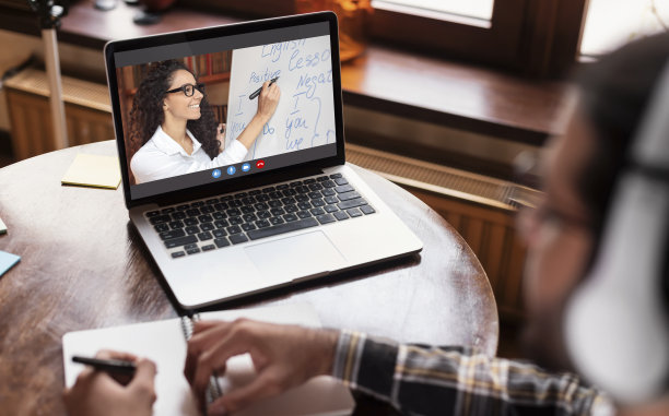 学生用笔记本电脑在室内在线学习英语图片下载