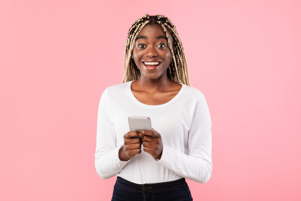 兴奋的黑人女士使用手机在演播室图片下载