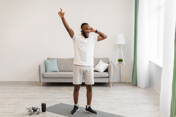 非洲男子戴着耳机在家锻炼图片下载