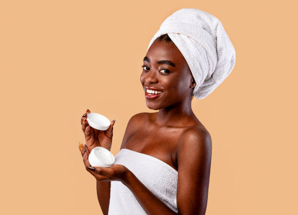 年轻漂亮的非洲裔美国女人，手里拿着一瓶奶油图片下载