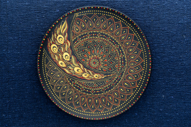 装饰瓷板用黑、红、金三种颜色，漆板的背景是蓝色的织物，点画图片下载