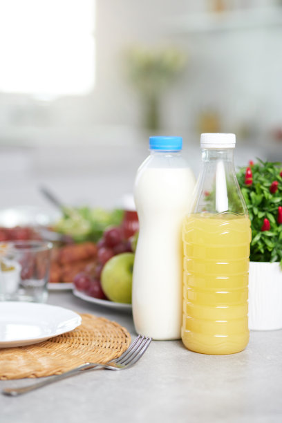 近距离的瓶装牛奶和橙汁提供拉丁美洲的早餐在现代厨房内部的桌子上图片下载