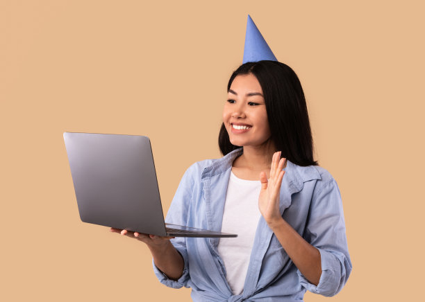 戴着帽子的快乐亚洲女人在笔记本电脑上做视频通话图片下载