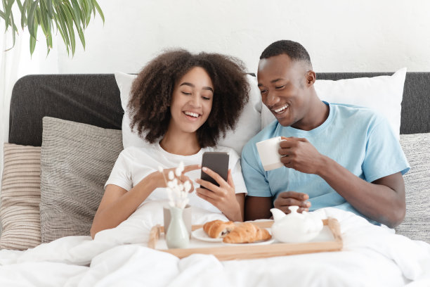 在床上吃早餐时阅读新闻、社交网络、优惠和广告图片下载