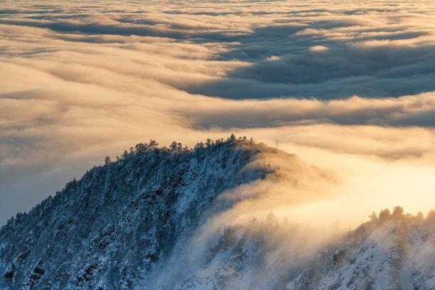 日出时的金色云彩覆盖了中国四川西部的雪山图片下载