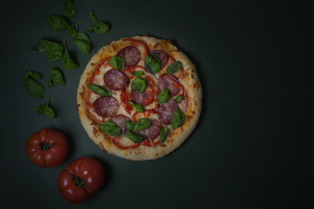 黑色背景下的飞行披萨。餐厅或披萨店的广告传单和海报的概念，一个用蔬菜和香草的热美味披萨特写模板。菜单图片下载