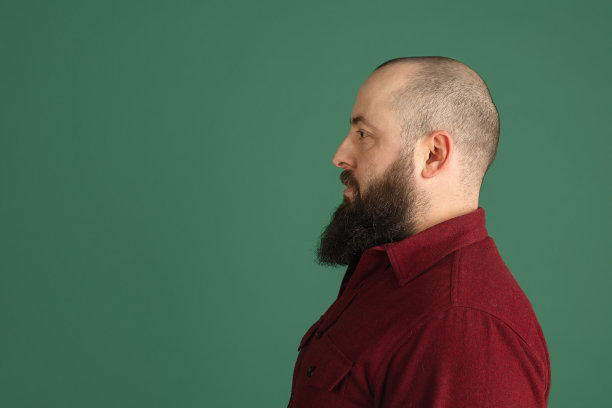 英俊的白人男子肖像孤立在绿色工作室背景与copyspace图片下载