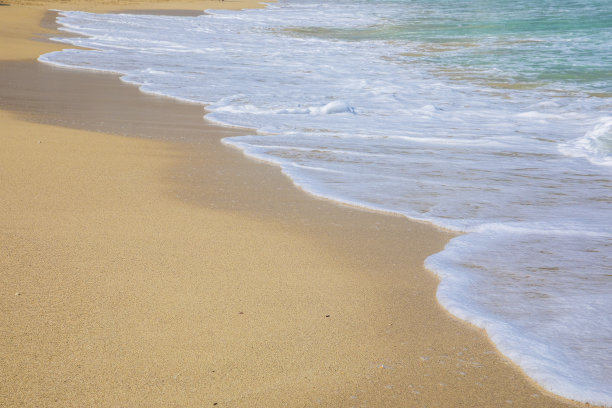 在沙滩上翻滚着泡沫的波浪图片下载