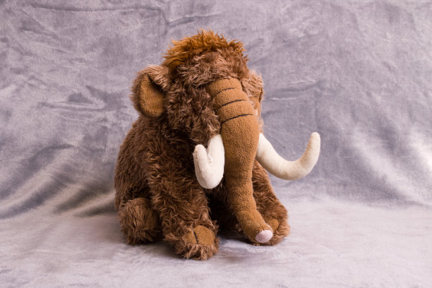 灰色背景上柔软的毛绒玩具大象图片下载