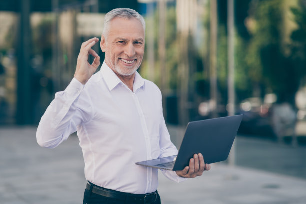 白发苍苍的老人照片在市中心户外做可以标牌拿着笔记本电脑图片下载