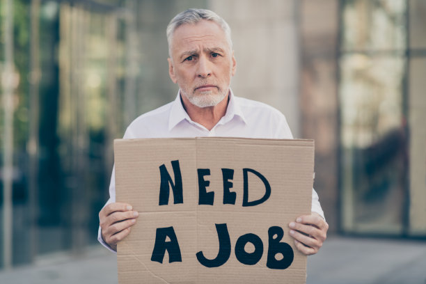 伤心不快乐的无业男子持证需要工作的照片在市中心的户外建筑物破产经济危机图片下载