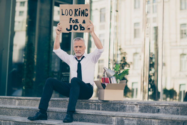 照片的不快乐绝望的年龄商人穿白衬衫失去工作拿着寻找工作的海报外的城市街道图片下载
