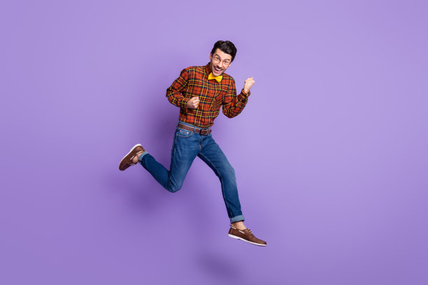 全尺寸照片的年轻英俊，愉快的微笑积极的男人跳跃在胜利孤立的紫色背景图片下载