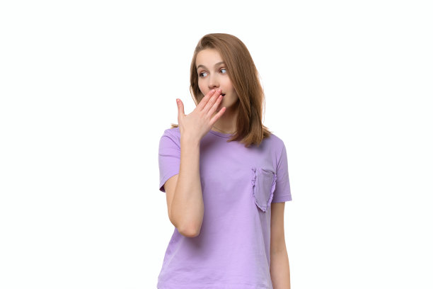 年轻女子用手捂着嘴，神情严肃，承诺保守秘密…工作室拍摄，白色背景图片下载