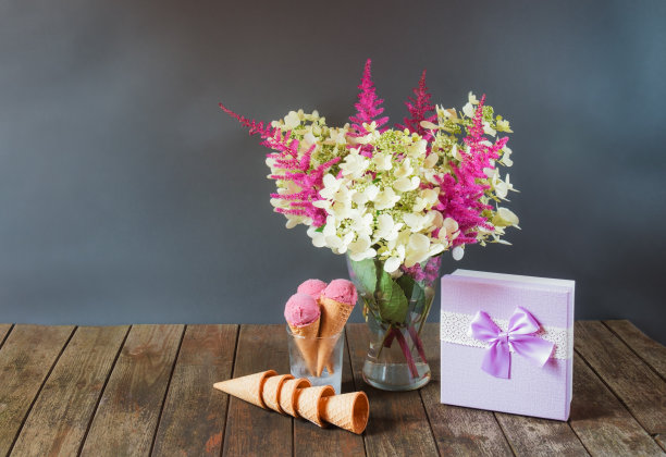 美丽的落新妇和绣球花，紫色礼盒和樱桃冰淇淋在木桌上。有选择性的重点。图片下载