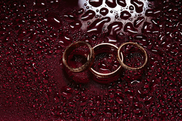 结婚戒指在暗色的水面上闪闪发光。雨,水滴图片下载