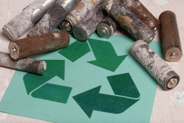 腐蚀电池使用。附近有一个废物回收的标志。特写镜头。图片下载