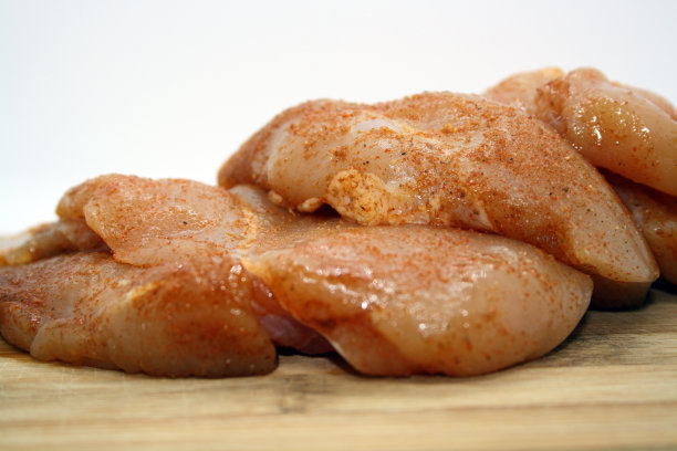 鸡柳片放在木板上。图片下载