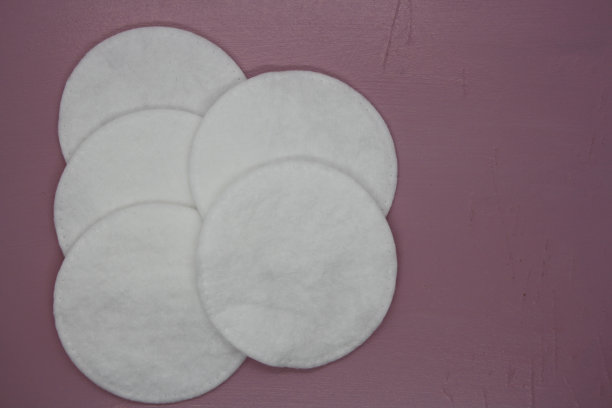 粉色背景上的白色棉垫。图片下载