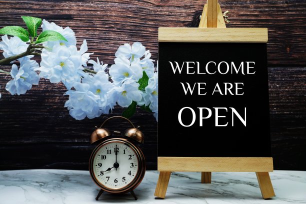 欢迎您的到来，我们将以闹钟为背景，以鲜花为装饰，以木色为背景，以开放的方式歌唱图片下载