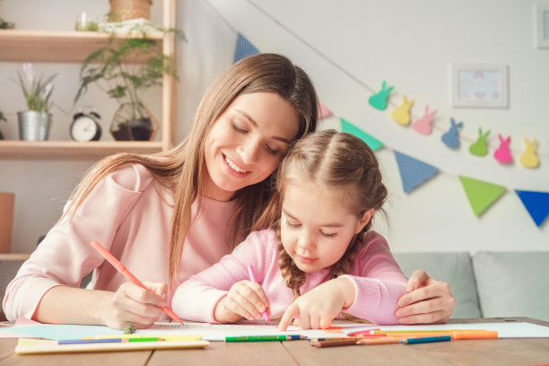 母亲和女儿周末一起在家拥抱画画图片下载